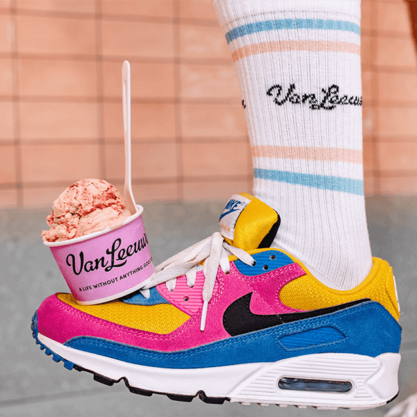 a photo of a foot wearing a van leeuwen athletic and a sneaker balancing a scoop of ice cream